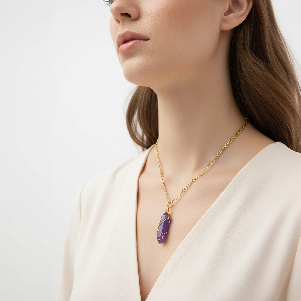 Woman wearing the goldlen Midnight crystal pendant on a white background